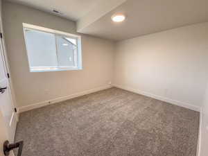 Spare room featuring baseboards and carpet floors