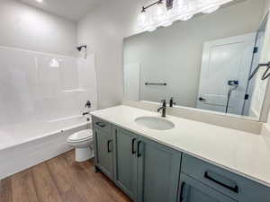 Full bathroom featuring wood finished floors, vanity, and tub / shower combination