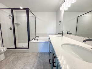 Full bath featuring a garden tub, a stall shower, double vanity, and a textured ceiling