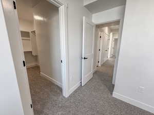 Hall featuring carpet floors and baseboards