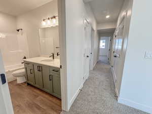 Bathroom with vanity, bathing tub / shower combination, wood finished floors, and recessed lighting