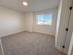 Unfurnished room featuring baseboards and carpet flooring