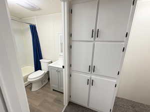 Full bath featuring wood finished floors, vanity, a textured ceiling, toilet, and shower / tub combo