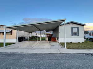 View of vehicle parking with an attached carport and concrete driveway