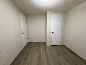 Spare room featuring wood finished floors and a textured ceiling
