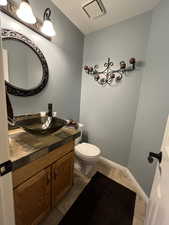 Bathroom featuring vanity, toilet, tile patterned floors, and baseboards