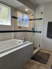 Full bath featuring a shower stall, tile patterned floors, a garden tub, and tile walls