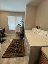 Clothes washing area with washing machine and dryer and baseboards