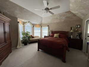 Bedroom with light colored carpet, lofted ceiling, and a ceiling fan