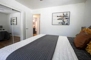 Bedroom with hardwood floors, a closet, and baseboards