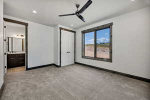 Unfurnished bedroom featuring light carpet, recessed lighting, ceiling fan, a closet, and ensuite bathroom