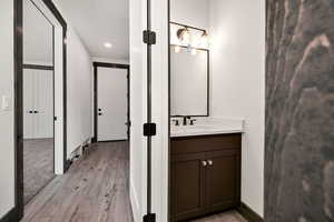 Bathroom featuring vanity, light wood-type flooring, and recessed lighting
