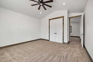 Unfurnished bedroom with light colored carpet, lofted ceiling, ceiling fan, a closet, and recessed lighting