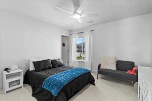 Bedroom featuring light colored carpet, ceiling fan
