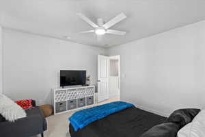 Carpeted bedroom featuring light carpet and ceiling fan