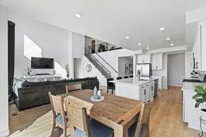 Dining space with stairs, light wood finished floors, and recessed lighting