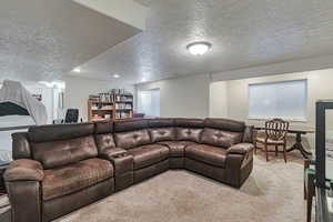 Living area featuring a textured ceiling and light colored carpet