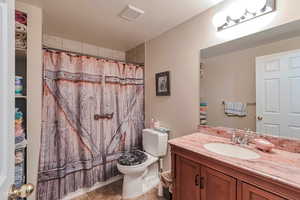 Full bath featuring toilet, vanity, a shower with curtain, and tile patterned floors