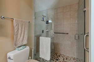 Bathroom featuring a stall shower and toilet