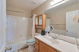 Full bath featuring toilet,  shower combination, vanity, and a textured ceiling