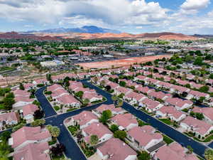 Aerial view of property and surrounding area with a mountainous background and nearby suburban area
