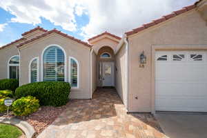 View of exterior entry featuring a garage and stucco siding