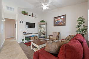 Living area featuring ceiling fan, light tile patterned floors, and baseboards
