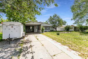 View of front of house featuring driveway and an attached carport