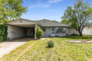 View of front of property featuring concrete driveway and a carport