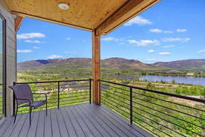 Wooden terrace featuring a water and mountain view
