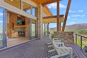 Wooden deck with an outdoor stone fireplace