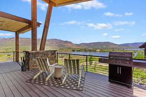 Wooden deck featuring a water and mountain view