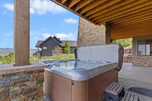 View of patio featuring a hot tub and a mountain view