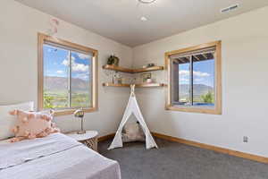 Bedroom featuring multiple windows, carpet, baseboards, and a mountain view