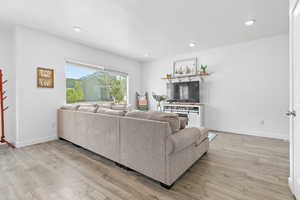 Living room with wood finished floors, recessed lighting, and baseboards