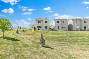 Rear view of house featuring stucco siding and a yard