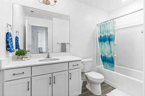 Full bathroom featuring toilet, wood finished floors, vanity, and shower / tub combo