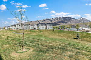 View of front of house with a residential view, a mountain view, and a front yard