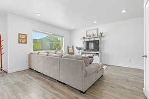 Living area with light wood-type flooring, recessed lighting, and baseboards