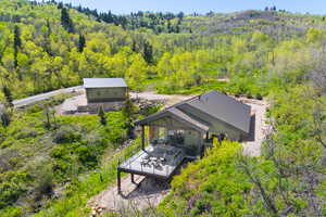 Aerial view of property and surrounding area with a forest