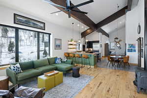 Living room featuring ceiling fan, light wood-style flooring, recessed lighting, a wood stove, and high vaulted ceiling