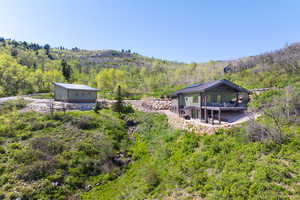 Back of property with a wooded view