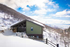 View of snow covered exterior with board and batten siding and a mountain view