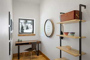 Office with light wood-style flooring and baseboards