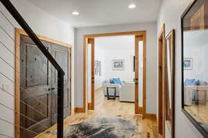 Hall featuring light wood-type flooring, stairs, recessed lighting, and baseboards