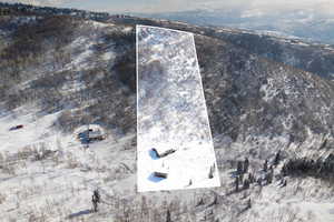 Snowy aerial view with property boundaries highlighted and a mountain view