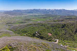Aerial view of property's location featuring mountains and a forest