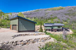 View of outbuilding featuring a mountain view and a view of trees