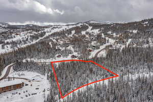 Snowy aerial view featuring a mountain view and property parcel outlined