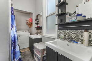 Full bathroom featuring washer / clothes dryer, decorative backsplash, tile patterned flooring, and vanity